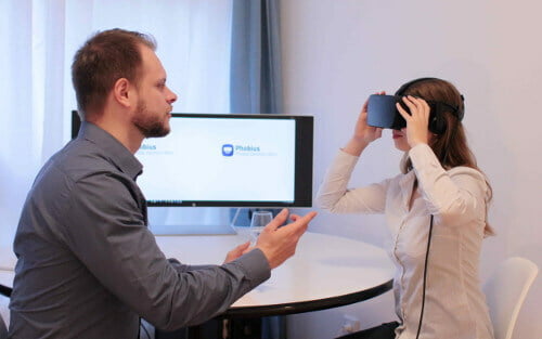 Johannes Lanzinger zeigt junger Frau VR-Brille